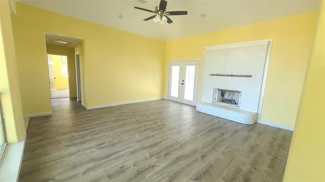 a view of a livingroom with wooden floor and a fireplace