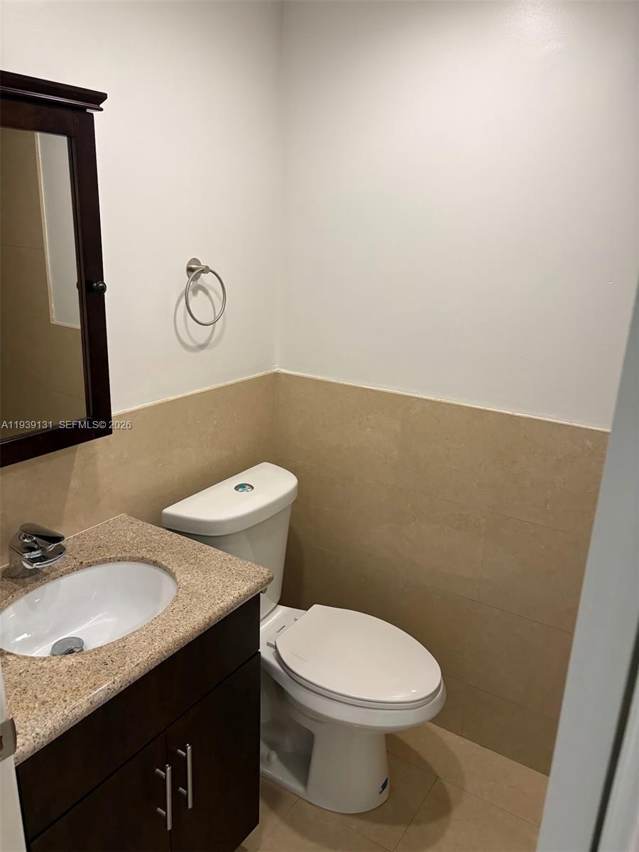 5555 Ludlam Road, Unit 25 South Miami, FL 33155 - Photo 23 of 27 a bathroom with a granite countertop toilet sink and mirror
