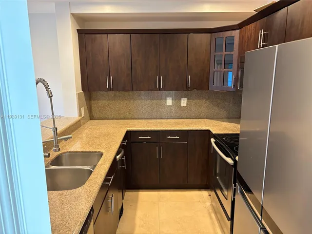 a kitchen with granite countertop a refrigerator and a sink
