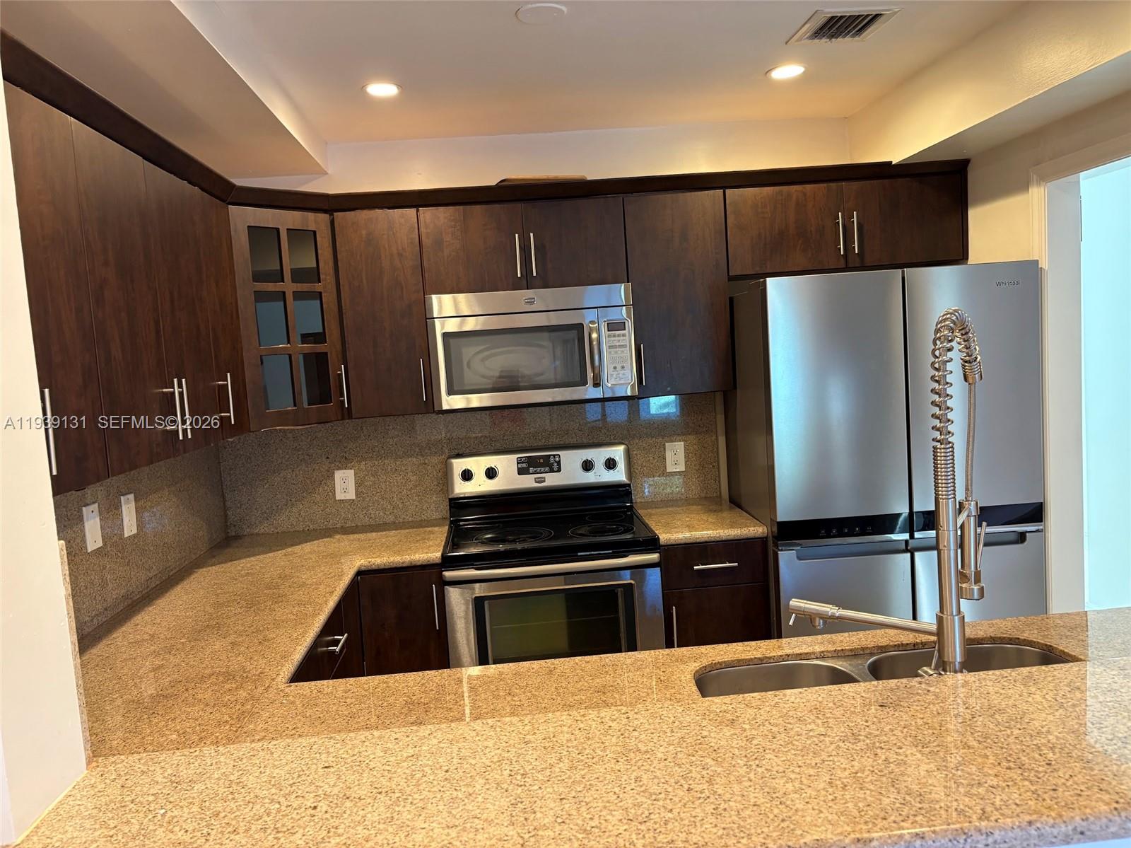 5555 Ludlam Road, Unit 25 South Miami, FL 33155 - Photo 7 of 27 a kitchen with granite countertop a refrigerator and a sink