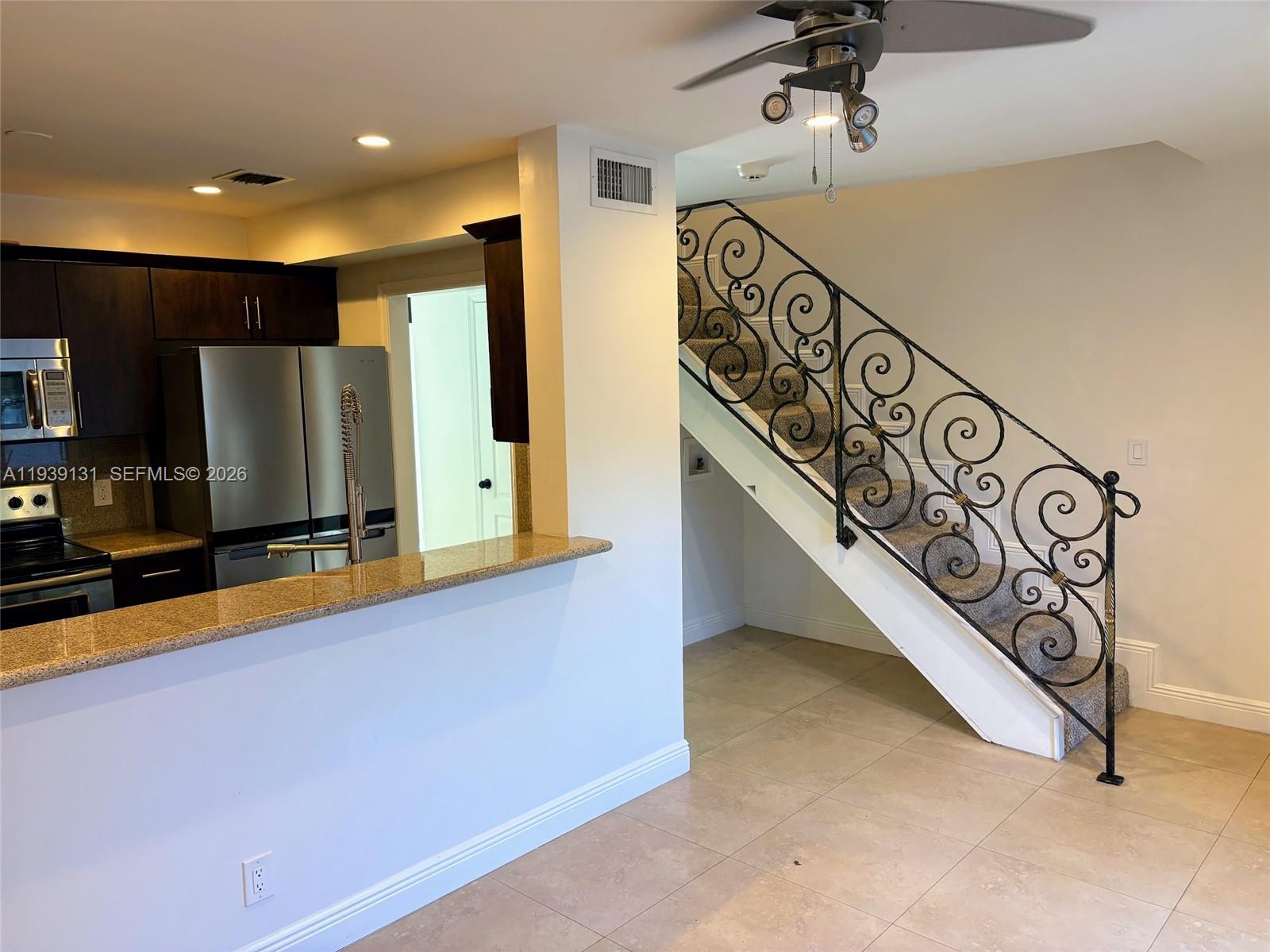 5555 Ludlam Road, Unit 25 South Miami, FL 33155 - Photo 8 of 27 a view of a kitchen with stainless steel appliances wooden floor and staircase