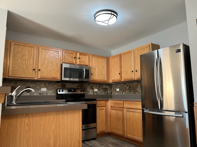1526 McClure Road, Unit 1526 Aurora, IL 60505 - Photo 5 of 12 a kitchen with stainless steel appliances granite countertop a refrigerator sink and microwave