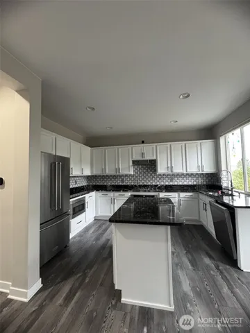 a kitchen with a refrigerator stove and wooden cabinets