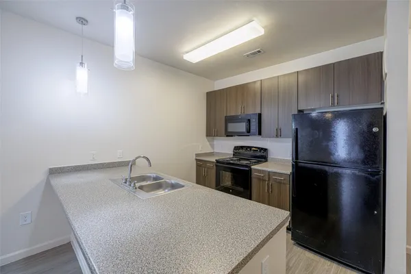 a kitchen with a refrigerator and a stove top oven