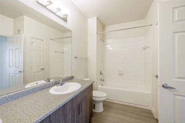 a bathroom with a granite countertop sink toilet and shower