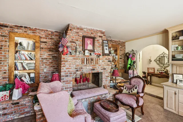 a view of a kitchen with kitchen island a counter top space a sink a stove and a refrigerator