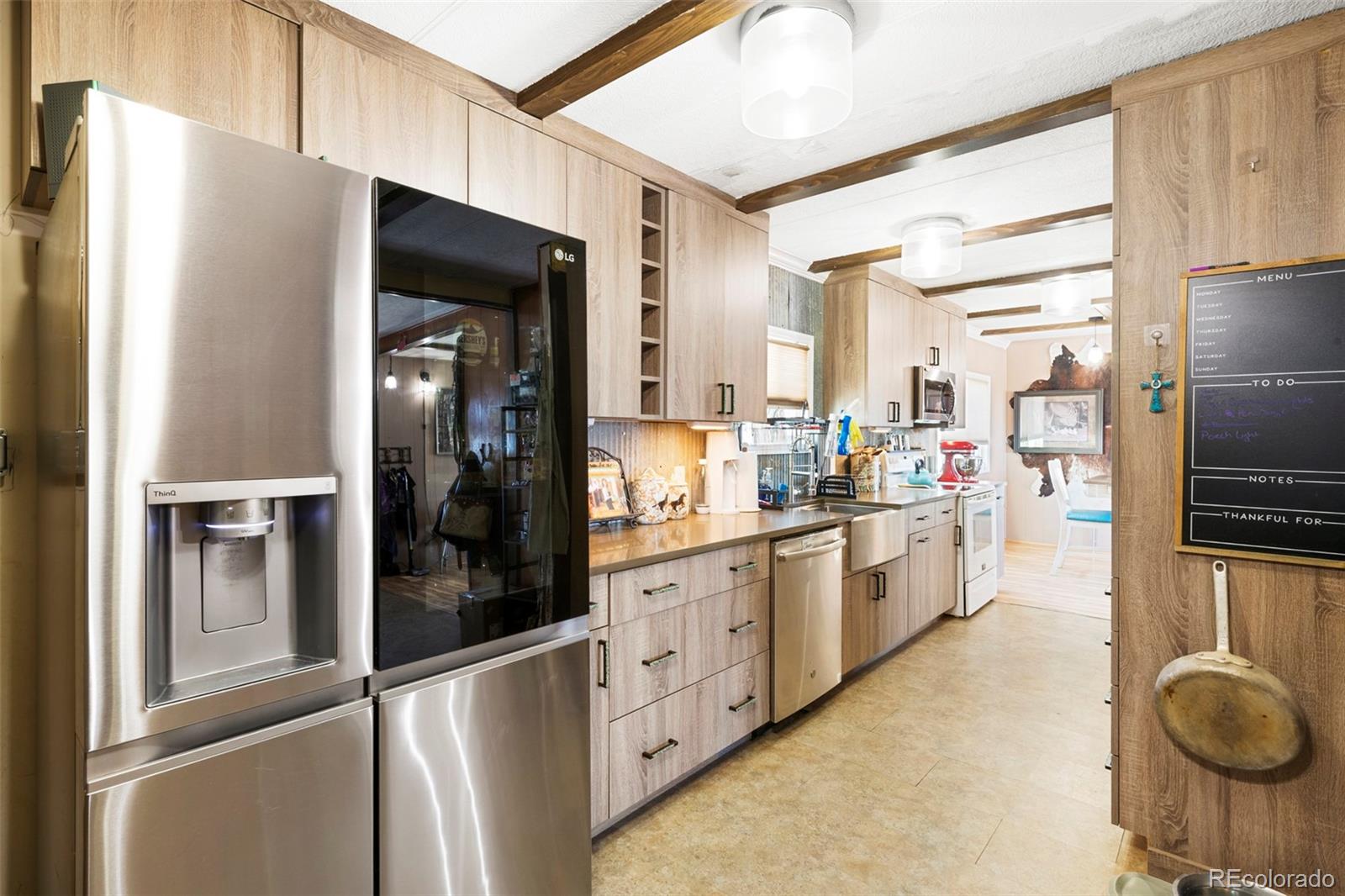 1382 Flintwood Road Franktown, CO 80116 - Photo 14 of 40 a kitchen with granite countertop a refrigerator and stainless steel appliances