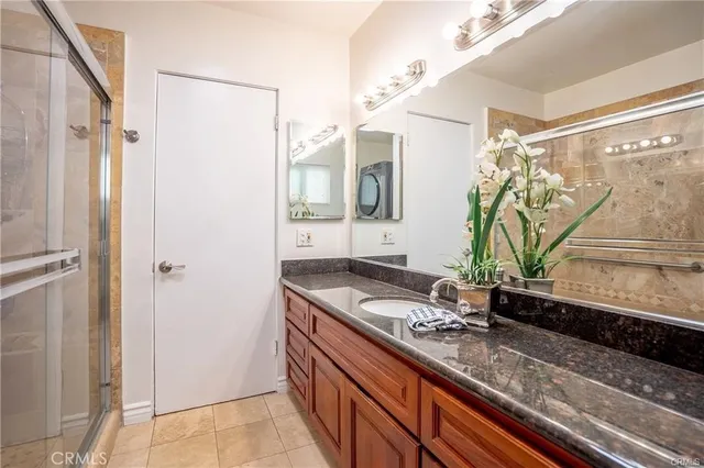 a bathroom with a granite countertop sink a mirror and a shower