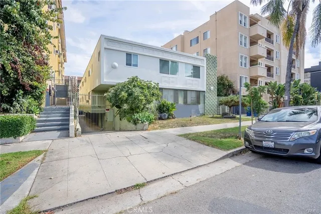 a view of building with cars parked