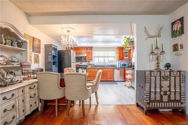 a dining room with furniture a chandelier and wooden floor
