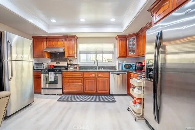 a kitchen with stainless steel appliances granite countertop a refrigerator and a stove top oven