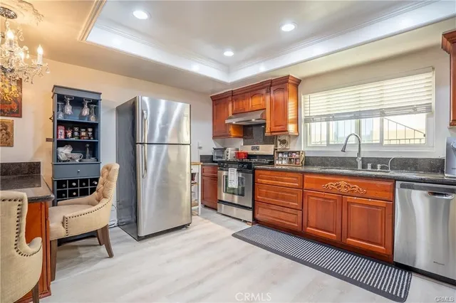 a kitchen with stainless steel appliances a refrigerator a sink a stove and cabinets