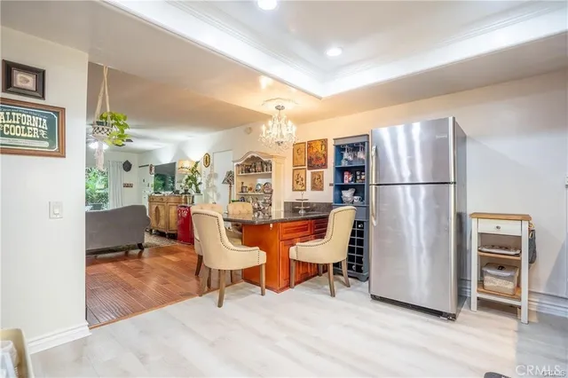 a living room with furniture a refrigerator and kitchen view