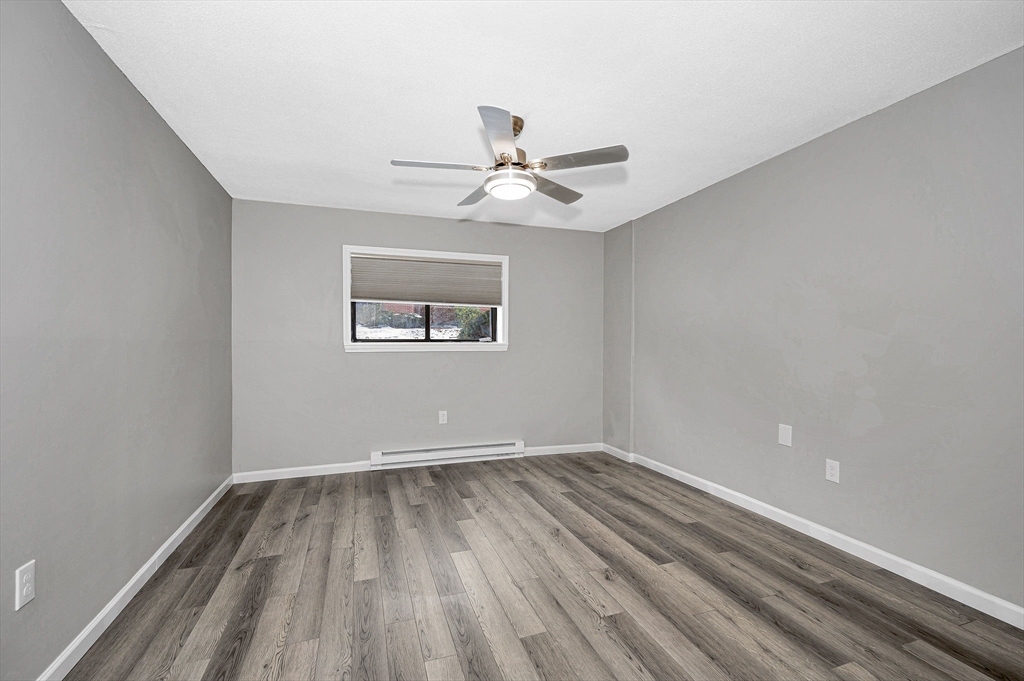 1241 Lawrence Street, Unit 101 Lowell, MA 01852 - Photo 14 of 27 wooden floor in an empty room with a window
