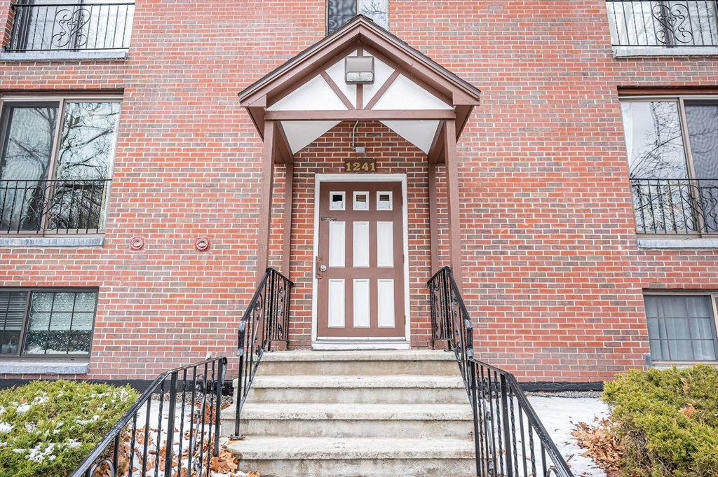 1241 Lawrence Street, Unit 101 Lowell, MA 01852 - Photo 21 of 27 a front view of a house with a yard