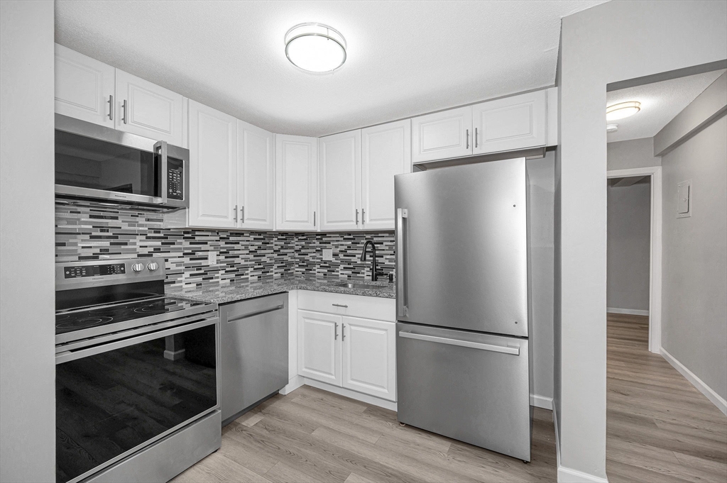 1241 Lawrence Street, Unit 101 Lowell, MA 01852 - Photo 7 of 27 a kitchen with stainless steel appliances a refrigerator sink and microwave