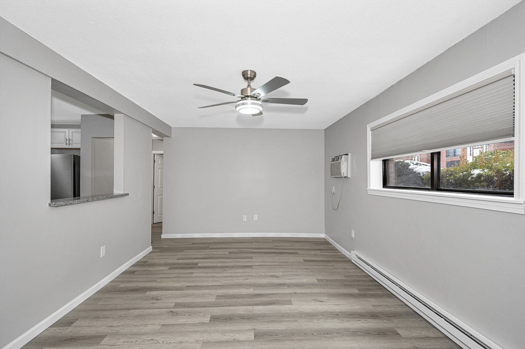 1241 Lawrence Street, Unit 101 Lowell, MA 01852 - Photo 9 of 27 a view of an empty room with window and wooden floor
