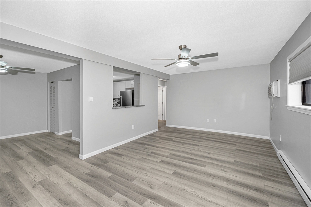1241 Lawrence Street, Unit 101 Lowell, MA 01852 - Photo 10 of 27 wooden floor in an empty room with a window