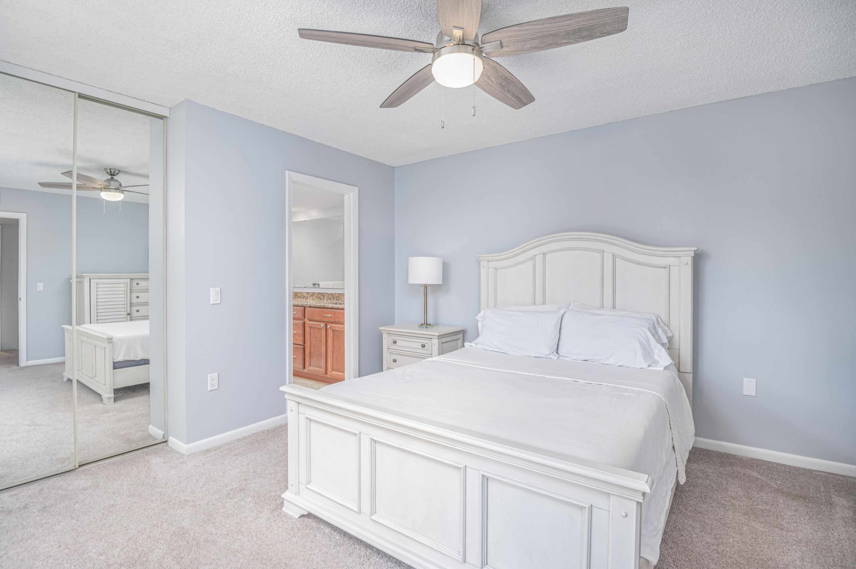 2980 Southwest Sunset Trace Circle Palm City, FL 34990 - Photo 18 of 21 a spacious bedroom with a bed and a chandelier