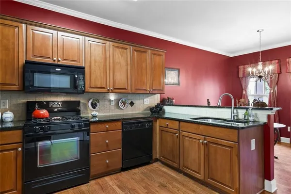 a kitchen with stainless steel appliances granite countertop a stove a sink and a microwave