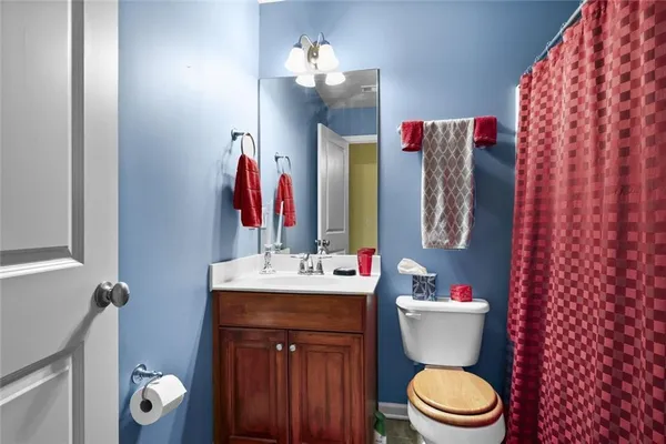 a bathroom with a sink vanity mirror and toilet