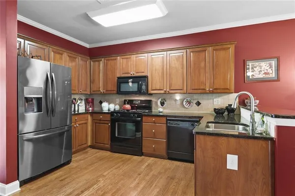 a kitchen with granite countertop stainless steel appliances and wooden cabinets