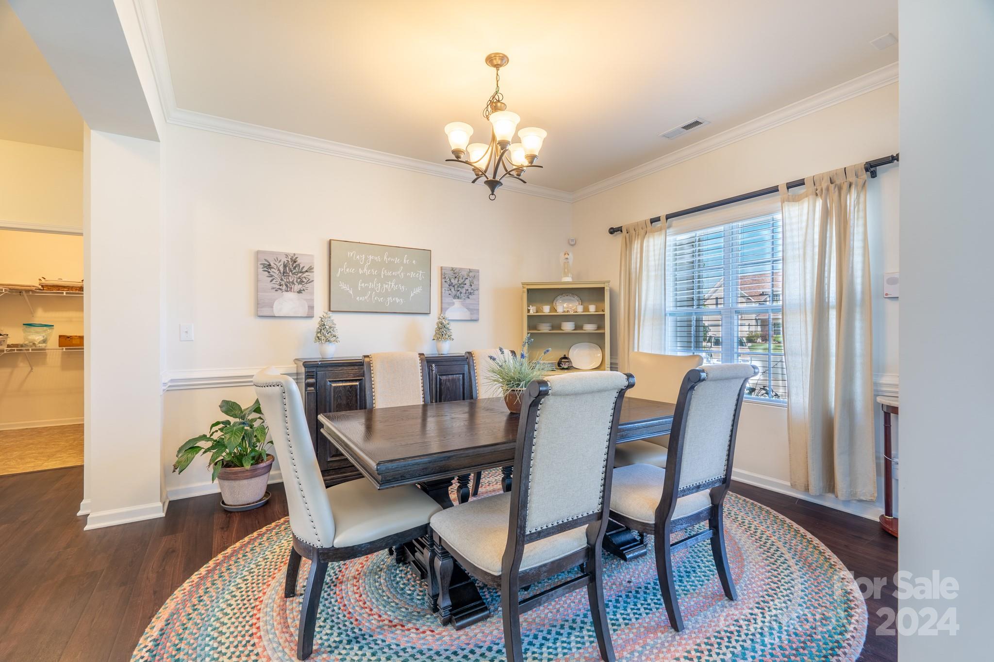 5396 Hackberry Lane Southwest Concord, NC 28027 - Photo 11 of 31 a view of a dining room with furniture a chandelier and wooden floor
