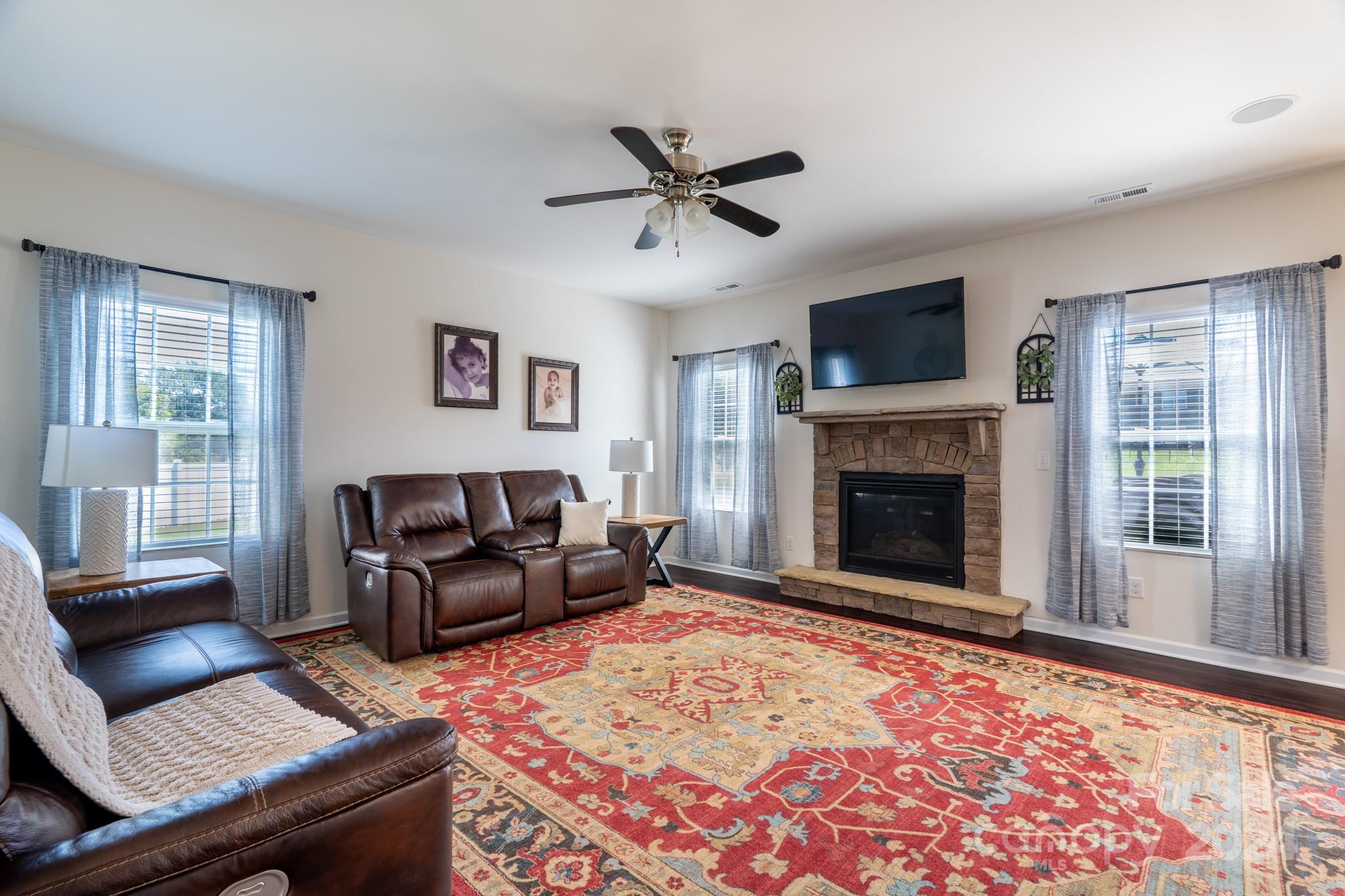 5396 Hackberry Lane Southwest Concord, NC 28027 - Photo 12 of 31 a living room with furniture a flat screen tv and a fireplace