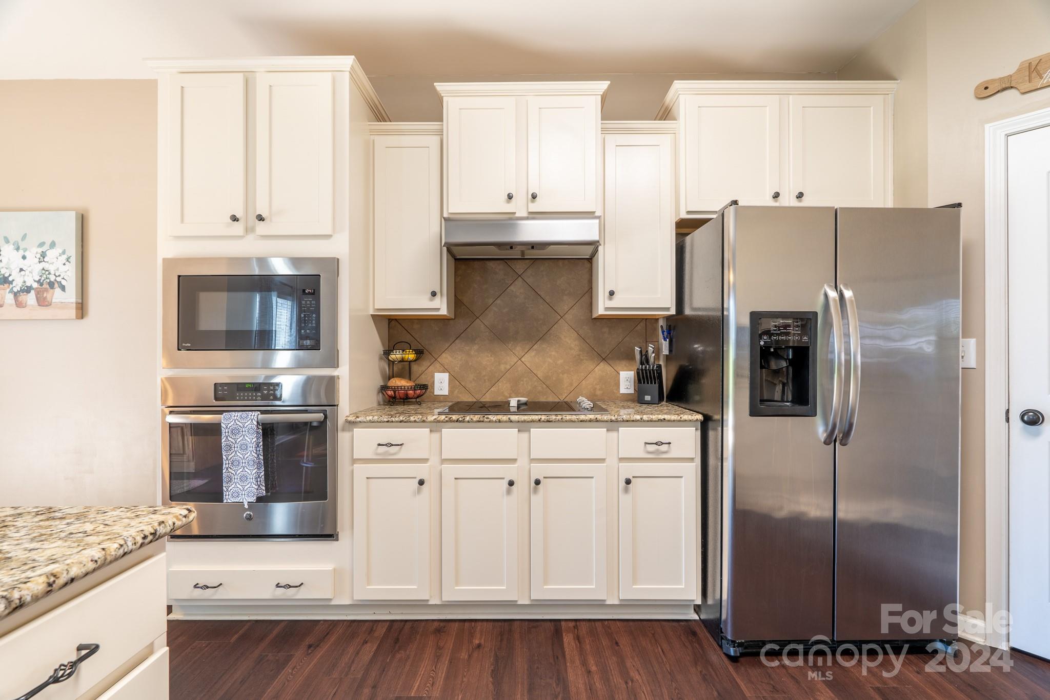 5396 Hackberry Lane Southwest Concord, NC 28027 - Photo 14 of 31 a kitchen with stainless steel appliances granite countertop a refrigerator a stove and a sink