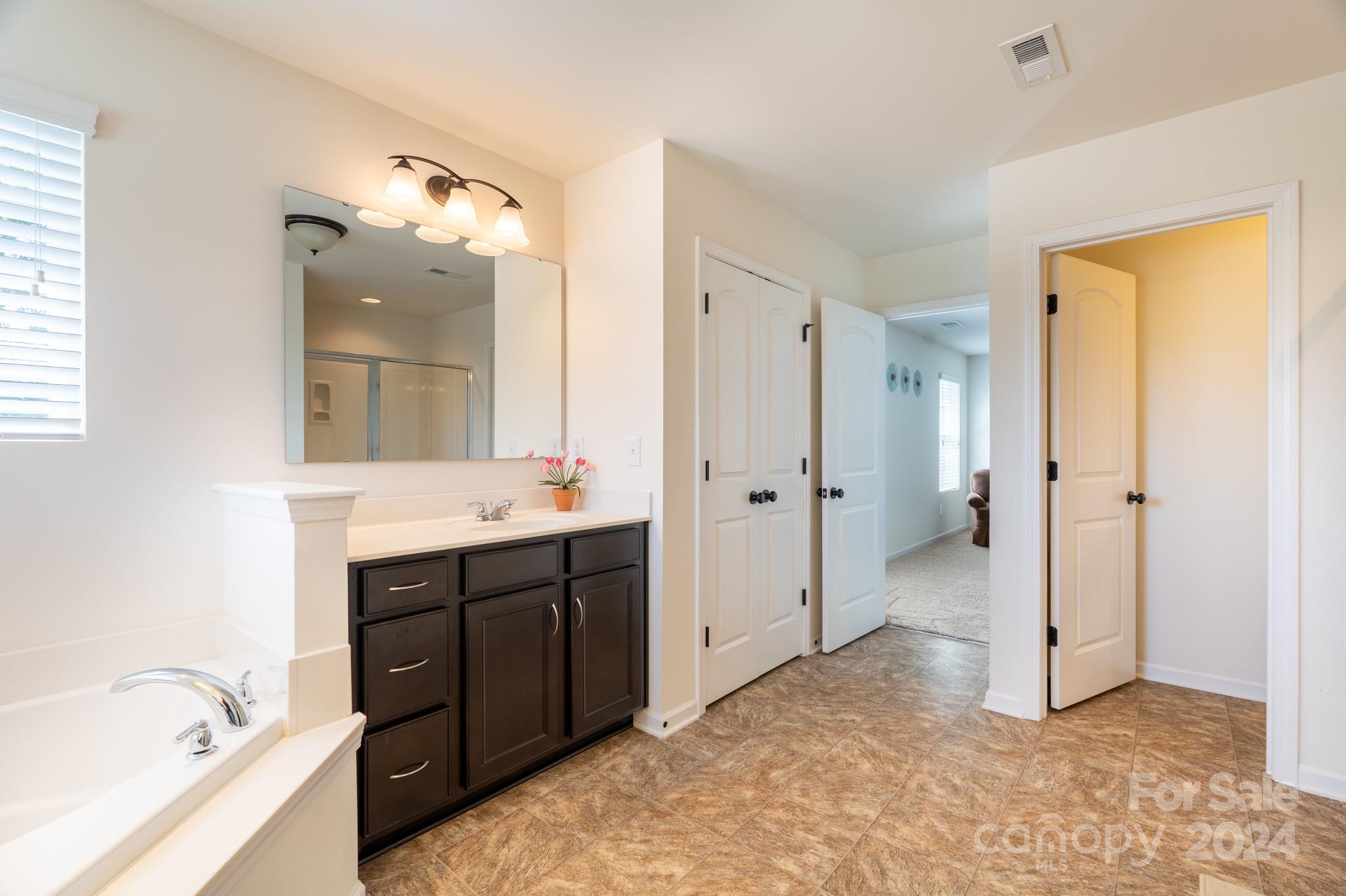 5396 Hackberry Lane Southwest Concord, NC 28027 - Photo 23 of 31 a spacious bathroom with a tub sink and mirror