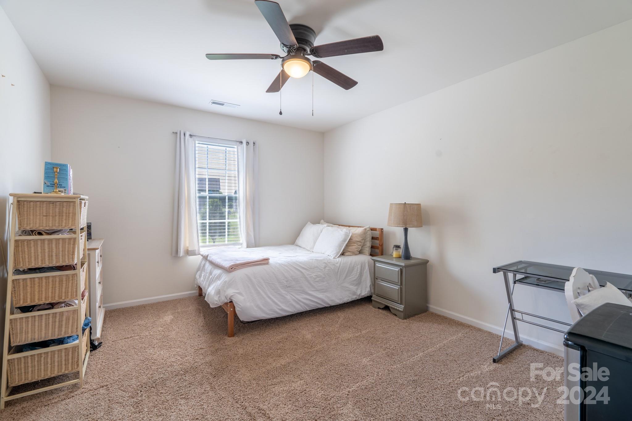 5396 Hackberry Lane Southwest Concord, NC 28027 - Photo 25 of 31 a bedroom with a bed and a ceiling fan
