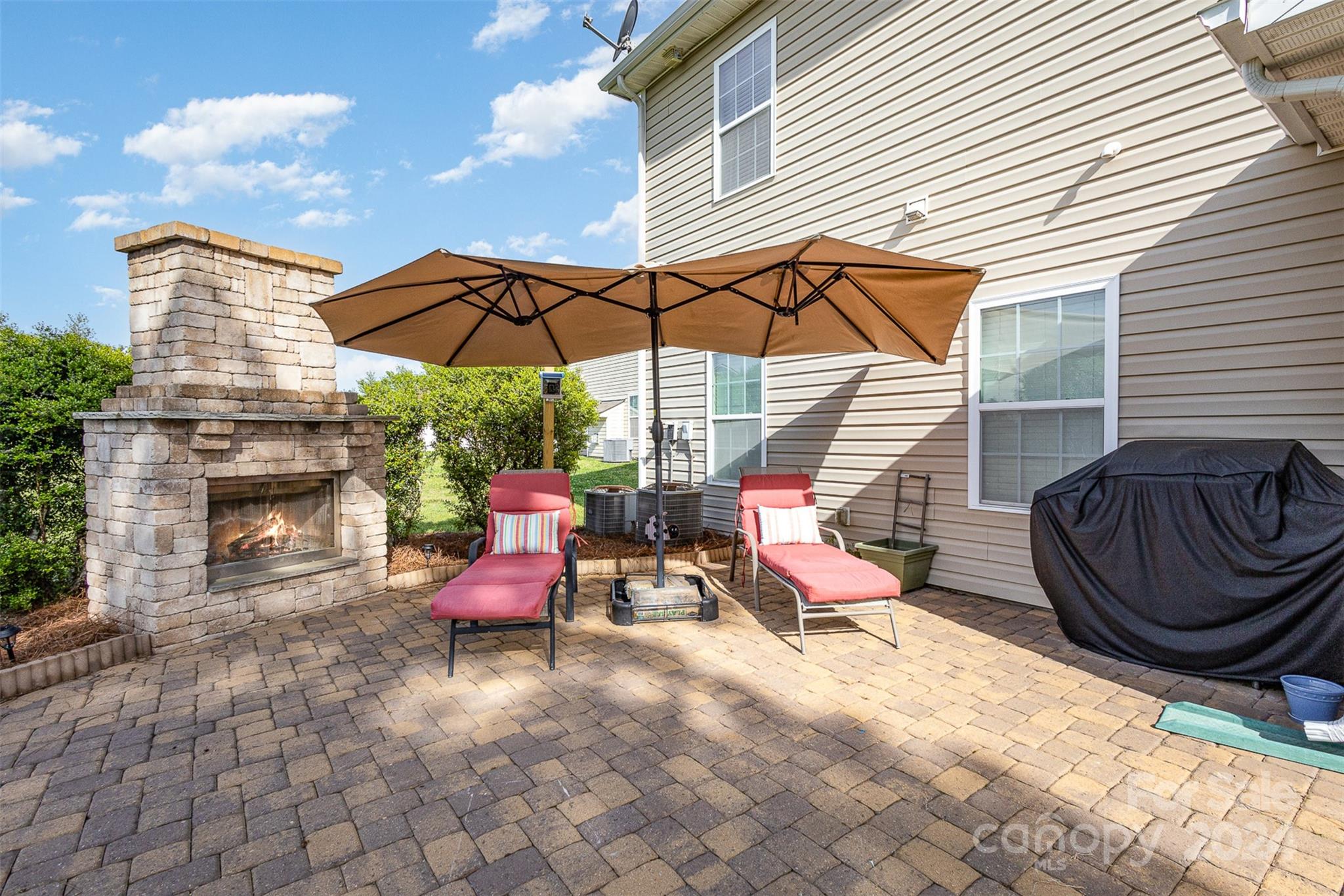 5396 Hackberry Lane Southwest Concord, NC 28027 - Photo 4 of 31 a view of a patio with a table and chairs under an umbrella