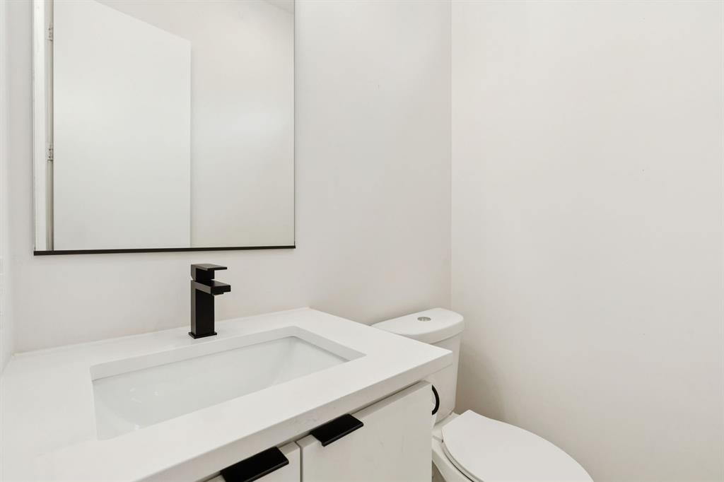 4119 Munger Avenue Dallas, TX 75204 - Photo 9 of 30 a bathroom with a sink a toilet and mirror