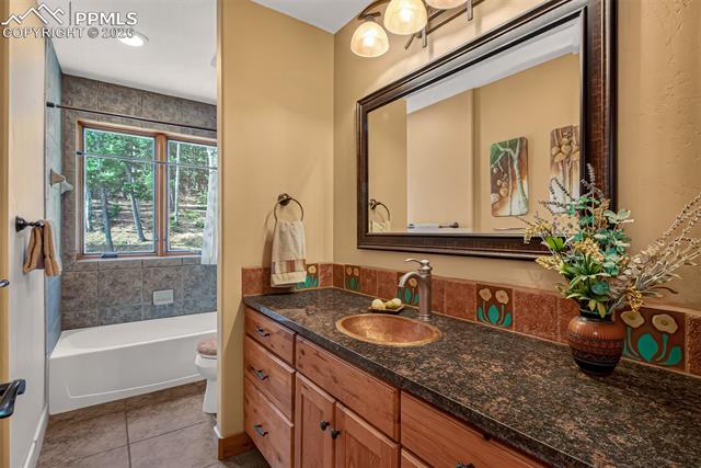 255 Summit Road Manitou Springs, CO 80829 - Photo 17 of 48 Full bathroom on the main level with a granite countertop with copper sink and Van Briggle tiled floor