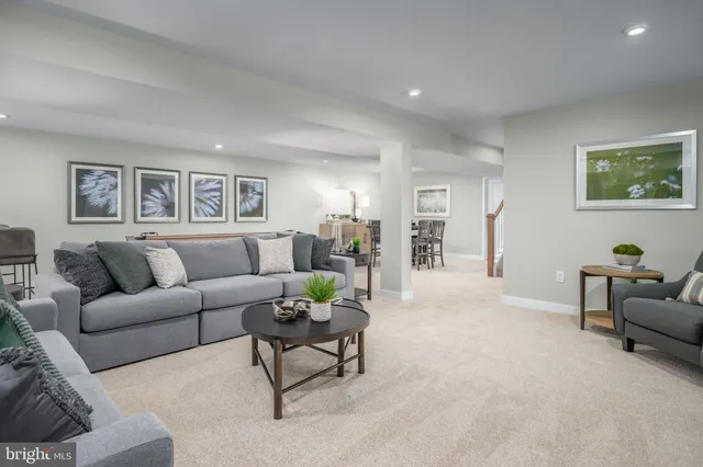 a living room with furniture and paintings on the wall