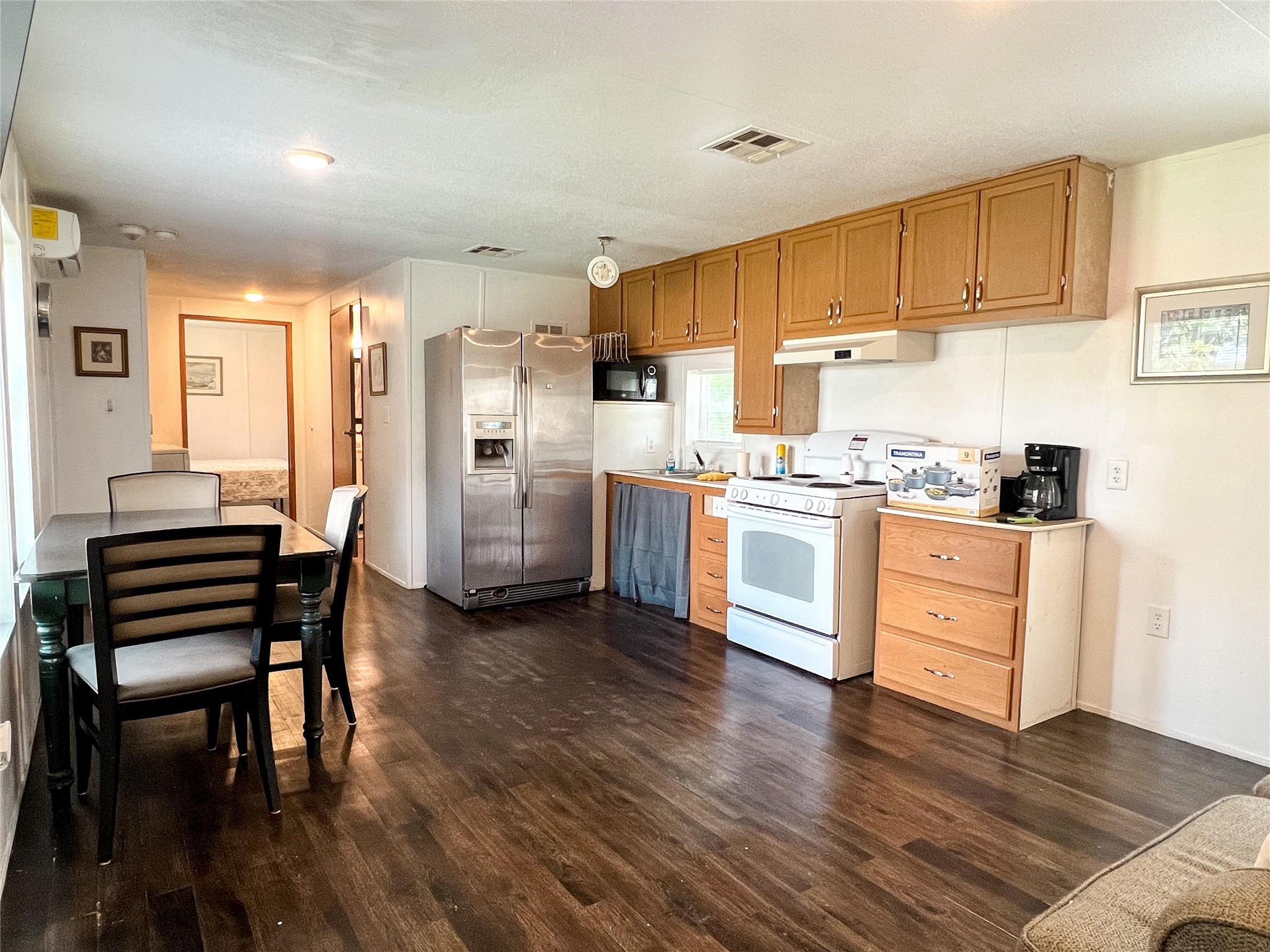 149 Devils Road Goodrich, TX 77335 - Photo 5 of 15 a kitchen with stainless steel appliances a stove a sink a refrigerator and white cabinets with wooden floor