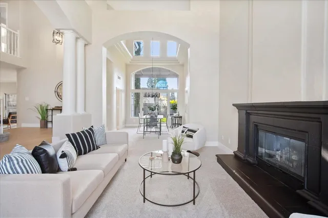 a living room with furniture a fireplace and a table