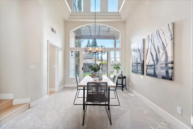 a view of a dining room with furniture a chandelier and wooden floor