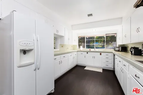 a kitchen with granite countertop white cabinets and white appliances