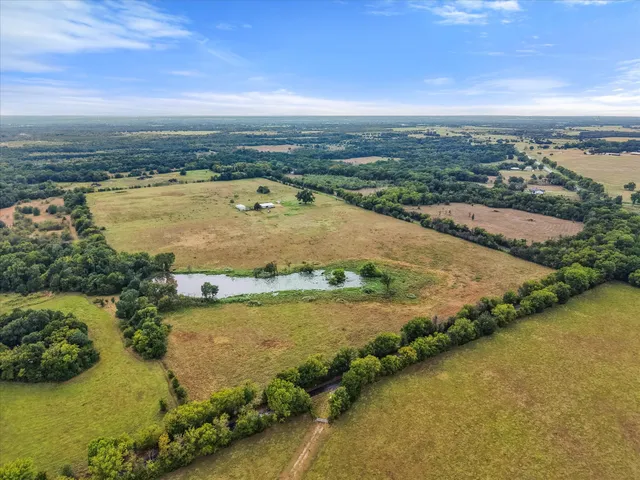 an aerial view of ocean and residential houses with outdoor space