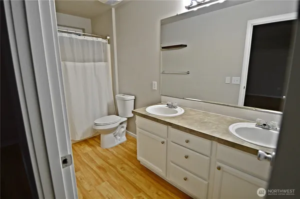 a spacious bathroom with a granite countertop sink toilet and shower