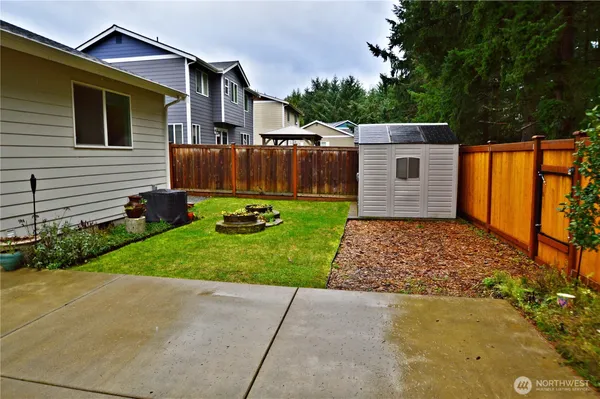 a backyard of a house with potted plants and wooden fence