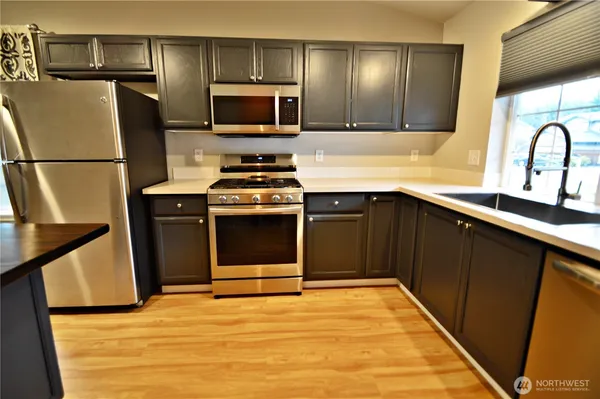 a kitchen with stainless steel appliances a stove a sink and a refrigerator