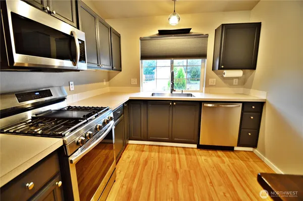 a kitchen with stainless steel appliances granite countertop a stove and a microwave