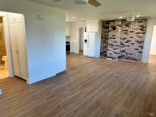 a view of empty room with wooden floor and entryway