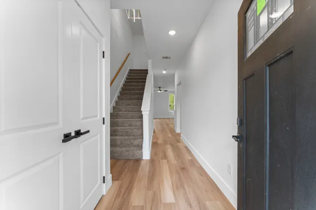 a view of a hallway with wooden floor and staircase