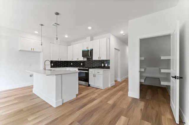 a kitchen with a refrigerator and a stove top oven