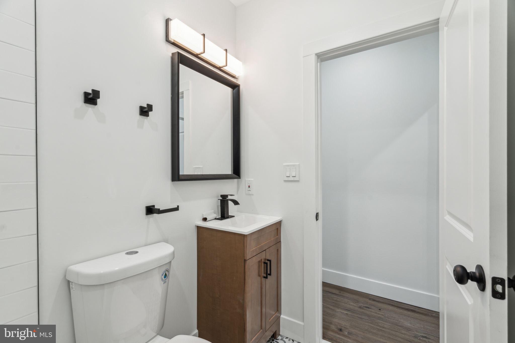 6013 Walnut Street Philadelphia, PA 19139 - Photo 14 of 21 a bathroom with a toilet sink and mirror