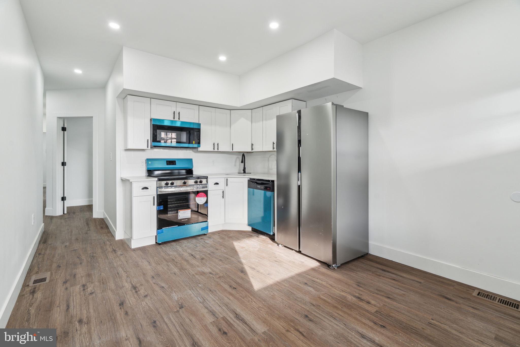 6013 Walnut Street Philadelphia, PA 19139 - Photo 5 of 21 a kitchen with stainless steel appliances a refrigerator and a wooden floor