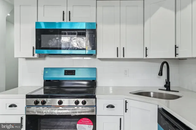 a kitchen with a sink cabinets and appliances
